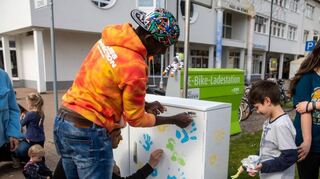 Lancin Diallo hilft den Jugendlichen beim Malen.