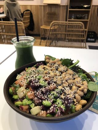 Eine Bowl mit reichlich Fisch, Gemüse und Nüssen.