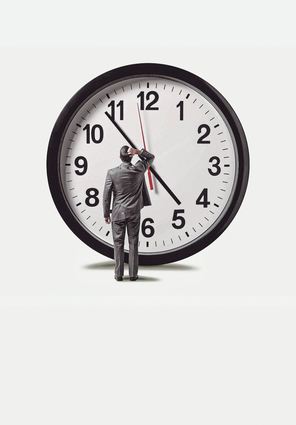 A businessman places his hand on top of his head as he looks up at a large clock that is getting close to five o'clock.  Isolated on a green background.