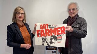 Grafiker Manfred Magin übergibt Doris Schröder vom Jazzinstitut Darmstadt seine historischen Konzertplakate.
