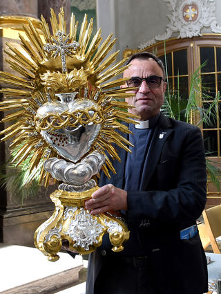 Dekan Karl Jung zeigt das durchstochene Herz Jesu mit Dornenkrone.
