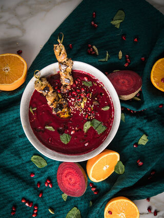 Mehr als ein Hingucker: Die Rote-Bete-Granatapfel-Suppe kann mit Hähnchen-Sesam-Spießen getoppt werden.