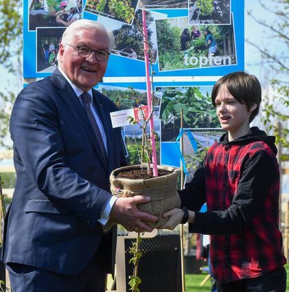 Frank-Walter Steinmeier bekommt von Magnus Emmert, Schüler der Tulla-Realschule, nach der Eröffnung der Bundesgartenschau einen Baumhaselsetzling, gezogen bei einem Projekt der „Grünen Schule“.