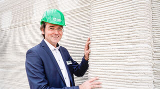 Jörg Dietrich vor einer Schicht für Schicht gedruckten Wand.