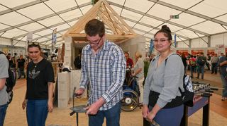 Mitmachen in der Halle des Handwerks: Vincent Wenninger bearbeitet eine Schieferplatte, daneben Lea Tritschler.