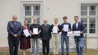 Schüler (2. und 3. v. r.) haben mit einer Lehrerin (2.v.l.) und einem Mitarbeiter der Schule (3.v.l.) einem Mitarbeiter der Abfallreinigung das Leben gerettet.