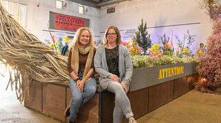 Zwischen dem Plakat vom Volksfest und dem Schild „Militärischer Sicherheitsbereich“: Petra Schwörer (l.) und Stephanie Büchler gestalteten die Hallenschau