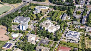 In der Nähe von Deutscher Universität für Verwaltungswissenschaften (oben), Pfälzischer Landesbibliothek (rechts darunter) und Landesuntersuchungsamt – Institut für Lebensmittelchemie (darunter) liegt am linken unteren Bildrand die Fläche für das geplante Containerdorf. Gegenüber: die Sporthalle „Judomaxx“ und das ehemalige Heizkraftwerk der Stadtwerke.