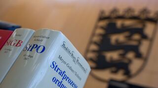 Im Landgericht stehen die Strafprozessordnung und das Strafgesetzbuch auf dem Richtertisch. +++ dpa-Bildfunk +++