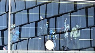 Passagiere mit Mundschutz winken, nachdem sie zuvor mit dem vorerst letzten Rückholflug aus Neuseeland auf dem Flughafen Wien gelandet waren.