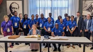 Aufs Wärmste empfangen fühlt sich Teamchef Ainsworth Irish (sitzend, r.) mit der Special-Olympics-Delegation aus Dominica in Ilvesheim und Ladenburg, wo sich am Dienstag auch die Landesbehindertenbeauftragte Simone Fischer (l.) in den Goldenen Büchern der beiden Gastgeberorte verewigt.