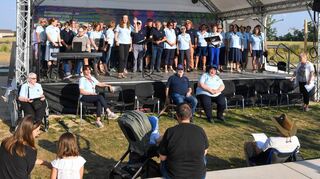 Der Buga-Chor der Teutonia Feudenheim auf der Bühne in der Parkschale der Bundesgartenschau mit Chorleiterin Katharina Linn.