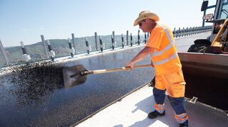 Hitze von oben und von unten: Ein Arbeiter asphaltiert bei Temperaturen von weit über 30 Grad den Fahrbahnbelag der Hochmoselbrücke.