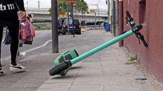 Achtlos abgestellte E-Roller werden oft zum Hindernis. Hier umkurven Fußgänger im Bereich Kaiser-Wilhelm-Straße/Lorientallee einen umgekippten Scooter.