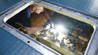 Armin Hönig, Mitarbeiter des Technikmuseums Sinsheim, arbeitet auf dem Gelände des Technikmuseums Speyer in einem Batterieraum des ausgemusterten U-Boots U17.