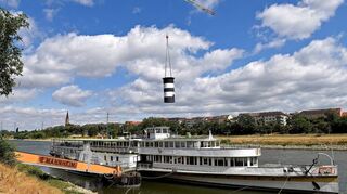 Weg ist er: Ein Kran hebt den Schornstein an – denn mit ihm käme das Museumsschiff auf der Fahrt zur Werft nach Köln nicht unter den Brücken durch.