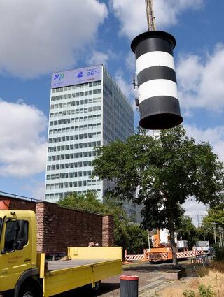 Hier kommt er: Der Schornstein wird auf den Lkw verladen.
