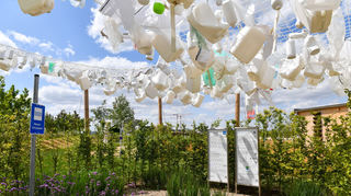 Über dem Garten „Leben unter Wasser“ schwebt eine Decke aus Plastikmüll, aufgehängt an einem Netz.