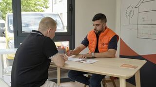 Beratung im Deutsche-GigaNetz-Container an der Kaiserstraße: Mohamed Boulayoun (r.) mit einem Kunden.