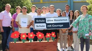 Sabrina Becker (r.) übergibt die Ernennungsurkunde als „Schule ohne Rassismus/Schule mit Courage“.