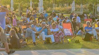 Buga-Besucher beim Sonnenuntergang auf Liegestühlen vor der Hauptbühne bei einem Konzert. 2944 Veranstaltungen haben schon stattgefunden.