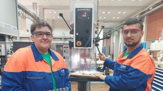 BASF-Auszubildender Levi Maksimov (links) unterstützt IB-Azubi Emirhan Erova bei den Arbeiten an der Bohrmaschine.