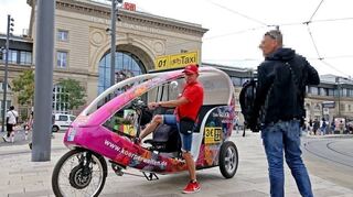 Rikscha-Fahrer Philipp Wiegand am Hauptbahnhof. Rechts von ihm der mögliche, aus juristischen Gründen im Gesicht gepixelte Täter.