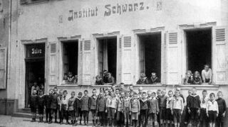 Um 1900 entstanden ist diese Aufnahme vom Institut Schwarz in M 3, 10. Der Herr im zweiten Fenster von links ist vermutlich Gründer Wilhelm Schwarz.