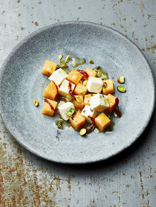 Für den Melonensalat mit Feta, getrockneten Tomaten und Pistazien hackt Heiko Antoniewicz Lavendelblüten und -blätter klein. Beides mit Olivenöl, weißem Balsamico, Honig, Zitronensaft und -schale sowie Salz und Cayennepfeffer zu einer Vinaigrette verrühren und mindestens 30 Minuten ziehen lassen.