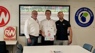 Im neuen Jugendraum: Übergabe des Zertifikats durch „Anpfiff“-Vorsitzenden Dietmar Pfähler (l.) und Projektleiter Sebastian Ebeling (r.) an Rot-Weiß-Chef Erwin Prudlik.