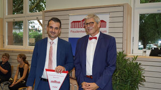 Gerrit Mennecke (l.) erhält den Wimpel des Feudenheim-Gymnasiums aus den Händen seines Vorgängers Rainer Halfar.