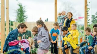 Tobias Krell – alias Checker Tobi – liest Mannheimer Kindern auf dem Generationen-Acker vor.