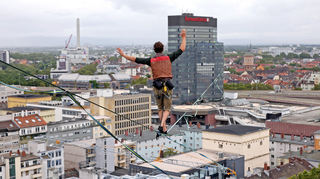 Zwischen Sparkassen-Gebäude und Rathaus-Turm ist ein Hochseilakt auf einer rund 300 Meter langen Slackline aufgebaut.