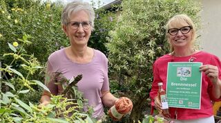 Gaby Kissel (l.) und Anette Jansen stehen hinter einer Brennnessel. Um diese nützliche Pflanze rankt sich auch eine Ausstellung im Alten Haus.