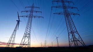 Windräder und Hochspannungsleitungen, aufgenommen am Morgen. Der Ausbau von Windrädern an Land nimmt weiter Fahrt auf. Der Bundesverband Windenergie beklagt allerdings seit längerem ein Nord-Süd-Gefälle: Während der Ausbau der Windkraft vor allem in Schleswig-Holstein, Niedersachsen, aber auch Nordrhein-Westfalen vorankommt, hinken Bayern und Baden-Württemberg hinterher. +++ dpa-Bildfunk +++