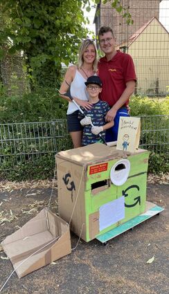 Yannik mit seinen Eltern Yvonne und Christian Bühler und dem Müllauto. In der Hand hat er seine zweite Greifzange, die erste ist schon kaputt.