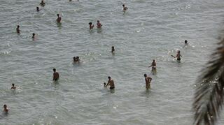 Menschen halten sich am Strand von Cala Major, in der Nähe von Palma auf Mallorca, im Wassr auf. Auf der spanischen Urlaubsinsel sind in diesen Tagen nicht nur der Sand und die Luft sehr heiß, sondern auch das Meereswasser erreicht ungewöhnlich hohe Temperaturen. (zu dpa Hitze auf Mallorca - Meer vor dem «Ballermann» wird zur warmen Brühe) +++ dpa-Bildfunk +++