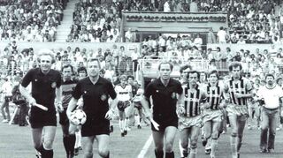 Schiedsrichter Dieter Pauly (mit Ball) führt die Teams aufs Feld. Von rechts: Dieter Schlindwein, Roland Dickgießer und Kapitän Günter Sebert.