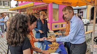 Bürgermeister Stefan Schmutz (r.) und Rathausmitarbeiterin Beate Glowinski verteilen zur Eröffnung Kerwekuchen an Gäste.