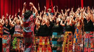 Chorleiterin Eva Buckman und der Mokoyam-Chor in dem sich ihre verschiedenen Ensemble vereinen.
