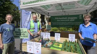 Vor dem Modell, das den Flächenfraß anschaulich macht: Stein Wanvik (v.l.) vom DAV, Wolfgang Guckert vom Kreisbauernverband und Christiane Kranz vom Nabu sammeln in der Heidelberger Hauptstraße Unterschriften für einen Volksantrag.