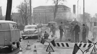 Das Bild zeigt den Friedrichsring im Februar 1955, als die Fahrbahndecke ausgebessert wurde. Im Hintergrund steht das Parkhotel.
