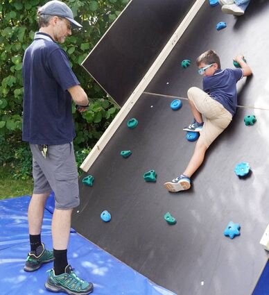 Matthias Brehm gibt den Kindern Tipps, wie sie am besten die Kletterwand hinauf und herunter kommen.