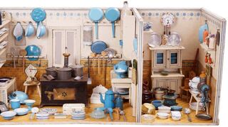 Die Puppenküche im Jugendstil mit geschlossenem Herd und Anrichteraum ist ganz weiß-blau dekoriert.