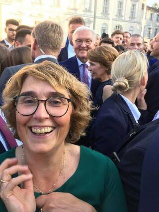 Dominque Ehrmantraut mit dem Bundespräsidenten im Hintergrund.