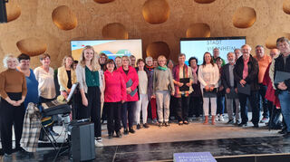 Können die Buga Mannheim schon fast als ihr Wohnzimmer ansehen: die Damen und Herren des Singkreises St. Aposteln mit Chorleiterin Martina Egli (vorne, 6.v.l.) im Pavillon der Metropolregion.