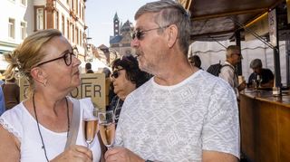 „Stößchen, mein Schatz!“ – Nachmittags bei allerbestem Spätsommerwetter lässt es sich vortrefflich auf die Maximilianstraße verweilen. Haide und Klaus genießen gerne ein Gläschen Sekt.