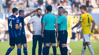 Während der fast zehnminütigen Unterbrechung gab es jede Menge Redebedarf. Auch Waldhof-Sportchef Tim Schork (3. v. l.) suchte das Gespräch mit Schiedsrichter Timo Gansloweit (re.), der sich dann in die Kabine zurückzog.