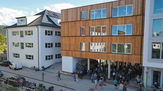Alt und neu: links ist der sanierte Altbau, die ehemalige US-Kaserne, zu sehen, rechts der Neubau mit Holzfassade.