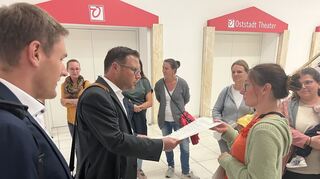 Elternbeiratsvorsitzende Alice van Scoter übergibt die Unterschriftenliste an Bürgermeister Volker Proffen. Ganz links Proffen-Referent Moritz Kuebart.